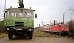 Dieser Tatra-Lkw steht am Bahnhof Bonn-Beuel auf der Laderape, an der im März 2003 die E-Lok 143 202 mit ihrem Zug vorbeifährt